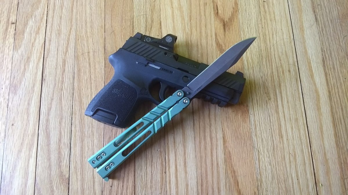 Alpha Beast Balisong on top of a Sig Sauer P320